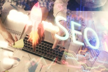 SEO hologram çizimleri ve birlikte çalışan kadın ve erkeğin çifte pozu. Arama motoru konsepti. Bilgisayar arkaplanı. Üst Görünüm.