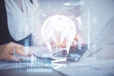 Bilgisayarda yazı yazan ve ampul çizen bir kadının ellerine iki kez maruz kalmış. Fikir kavramı.