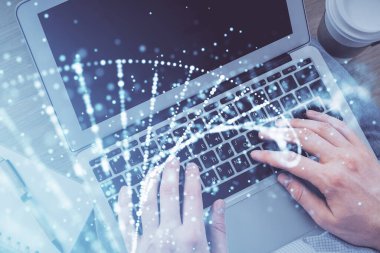 Bilgisayar klavyesinin ve DNA hologramının üzerinde yazarken iki kez görüntülenmiş. Üst Manzara. Tıp eğitimi kavramı.