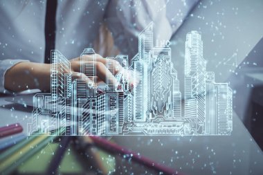 Bilgisayarda yazı yazan kadın elleri ve çizim yapan binalar. Akıllı şehir konsepti.
