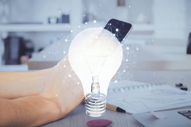 Dijital bir cihaz ve ampul hologram çizimi kullanarak insanın ellerini tutarken çift pozlama. Fikir kavramı.