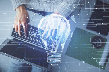 Bilgisayar ve ampul hologramı çizimleri üzerinde çalışan kadın elleri çift pozlama. Üst Manzara. Fikir kavramı.