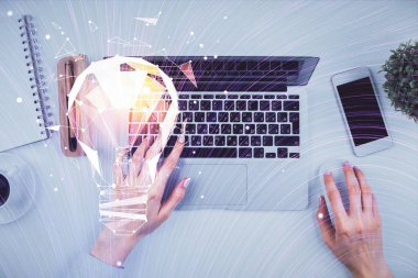 Bilgisayar ve ampul hologramı çizimleri üzerinde çalışan kadın elleri çift pozlama. Üst Manzara. Fikir kavramı.