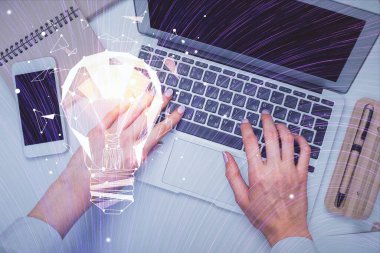 Bilgisayar ve ampul hologramı çizimleri üzerinde çalışan kadın elleri çift pozlama. Üst Manzara. Fikir kavramı.