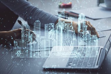 Bilgisayarda yazı yazan kadın elleri ve çizim yapan binalar. Akıllı şehir konsepti.