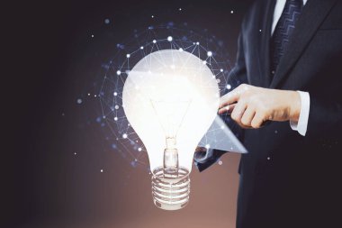 Dijital bir cihaz ve ampul hologram çizimi kullanarak insanın ellerini tutarken çift pozlama. Fikir kavramı.