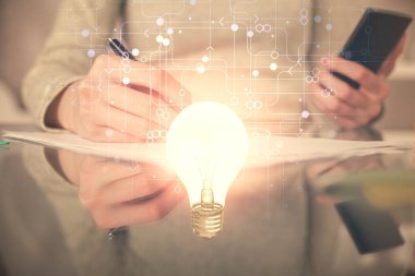 Ampul hologramına çift pozlama ve mobil cihaz kullanan bir kadın. Fikir kavramı.