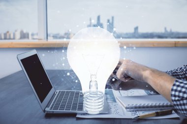 Dijital bir cihaz ve ampul hologram çizimi kullanarak insanın ellerini tutarken çift pozlama. Fikir kavramı.