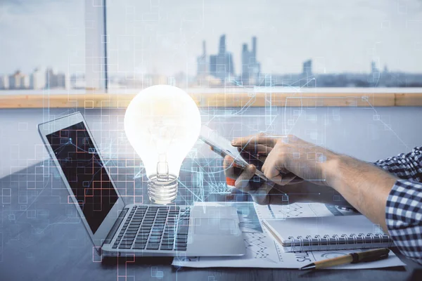 Dijital bir cihaz ve ampul hologram çizimi kullanarak insanın ellerini tutarken çift pozlama. Fikir kavramı.