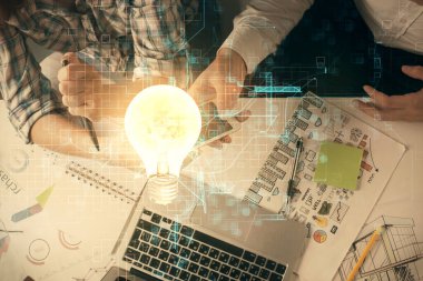 Ampul hologramı ve kadın ve erkeğin birlikte çalışıp mobil bir cihaz kullanması. Fikir kavramı