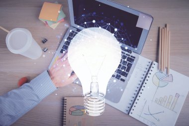 Bilgisayar klavyesi ve ampul hologramı çizimlerinin üzerine iki kez yazı yazan bir adamın eline maruz kalmak. Üst Manzara. Fikir kavramı.