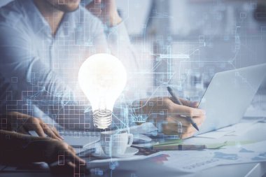 Erkek ve kadının birlikte çalıştığı ve ampul hologramının çizildiği çifte çekim. Fikir konsepti. Bilgisayar arkaplanı.