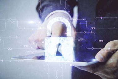 Dijital bir cihaz ve kilit çizimi kullanan bir adamın el ele tutuşması. Güvenlik kavramı.