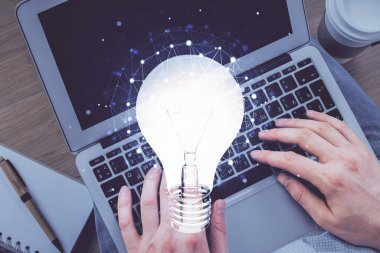 Bilgisayar klavyesi ve ampul hologramı çizimlerinin üzerine iki kez yazı yazan bir adamın eline maruz kalmak. Üst Manzara. Fikir kavramı.