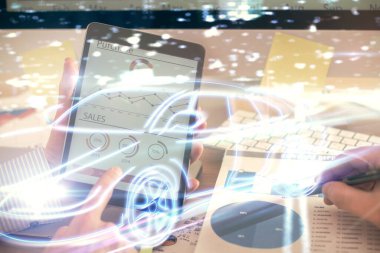 Dijital bir cihaz ve otomobil temalı hologram çizimi kullanarak insanın elini tutarken çift pozlama. Teknoloji konsepti.