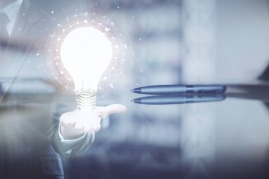 Ofisteki kahve fincanı arka planında ampul hologramına iki kez maruz kalmış. Fikir kavramı
