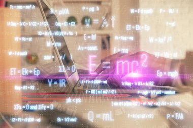 Bilgisayarda ve formüllü hologram çizimlerinde kadın elinin çifte pozu. Eğitim kavramı.