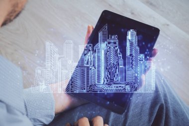 Dijital bir cihaz ve şehir çizimi kullanarak insanın ellerini tutarken çift pozlama.