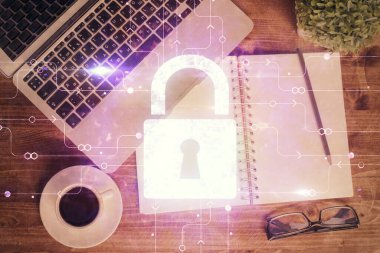 Bilgisayarla çalışma masası arkaplanının üzerine iki kat kilit hologramı çiziliyor. Veri güvenliği kavramı. Üst görünüm.