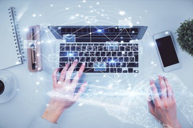Bilgisayarda çalışan ve hologram çizimlerini kaplayan kadın ellerini iki kez gösteriyor. Üst Manzara. E- posta konsepti.