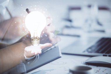 Arka planda not alan insanların üzerine çizim yapan ampullerin çifte pozu. Fikir kavramı