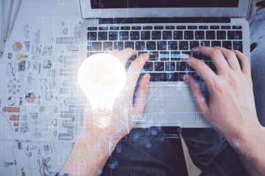 Bilgisayar klavyesi ve ampul hologramı çizimlerinin üzerine iki kez yazı yazan bir adamın eline maruz kalmak. Üst Manzara. Fikir kavramı.