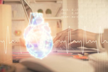 Bilgisayarda ve kalp hologramı çizimlerinde kadın elinin çifte pozu. Eğitim kavramı.