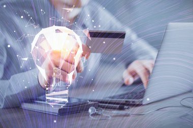 Elinde bir kredi kartı ve ampul çizimi olan bir adamın ellerine iki kez maruz kalmış. Fikir E-ticaret kavramı.