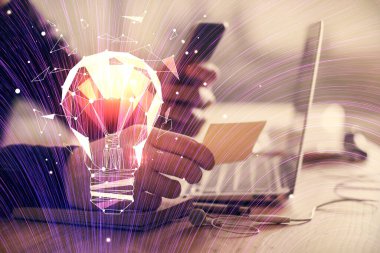 Dijital bir cihaz ve ampul hologram çizimi kullanarak insanın ellerini tutarken çift pozlama. Fikir kavramı.