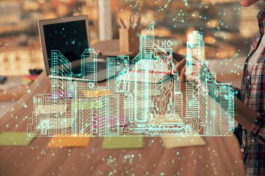 Bilgisayarda yazı yazan kadın elleri ve çizim yapan binalar. Akıllı şehir konsepti.