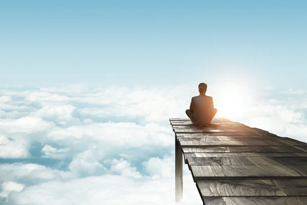 Businessman sitting on pier — Stock Photo, Image