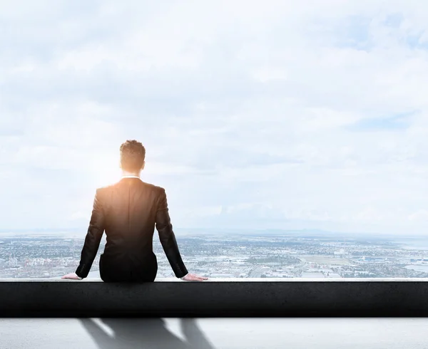 Uomo d'affari seduto sul tetto — Foto Stock