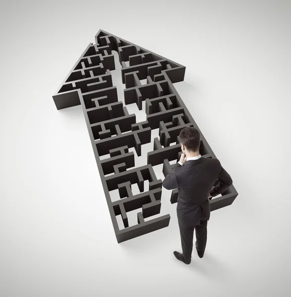 Businessman standing in arrow form maze — Stock Photo, Image