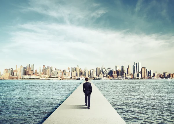 Hombre de negocios en traje caminando sobre puente de hormigón — Foto de Stock