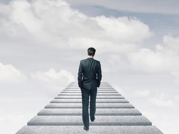 Hombre de negocios en traje caminando por el cielo — Foto de Stock