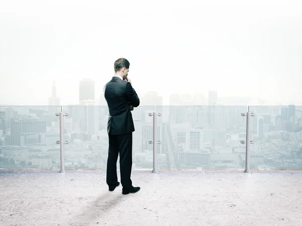 Businessman thinking standing on roof Stock Photo