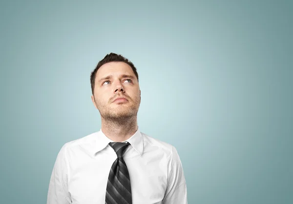 Young businessman thinking on blue background Royalty Free Stock Images