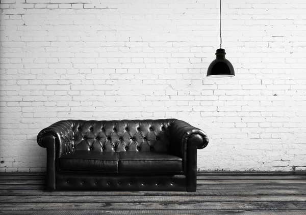 Salle de briques avec lampe et canapé en cuir — Photo