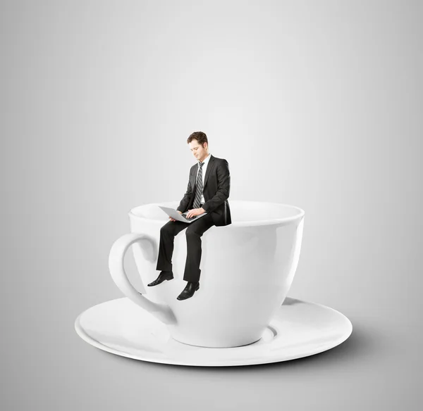 Бизнесмен сидит на чашке кофе — стоковое фото