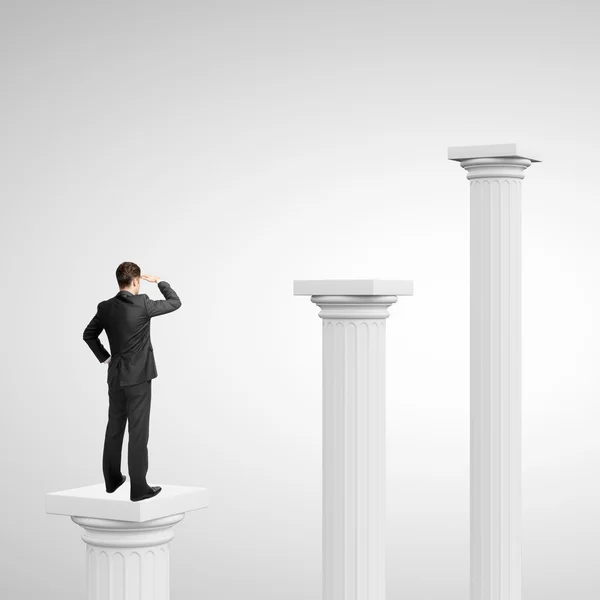 Businessman standing on column — Stock Photo, Image