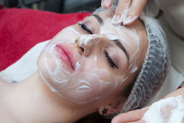 Kvinna med ansiktsmask på skönhetssalong — Stockfoto