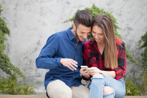 Jeune couple utilisant un téléphone intelligent — Photo