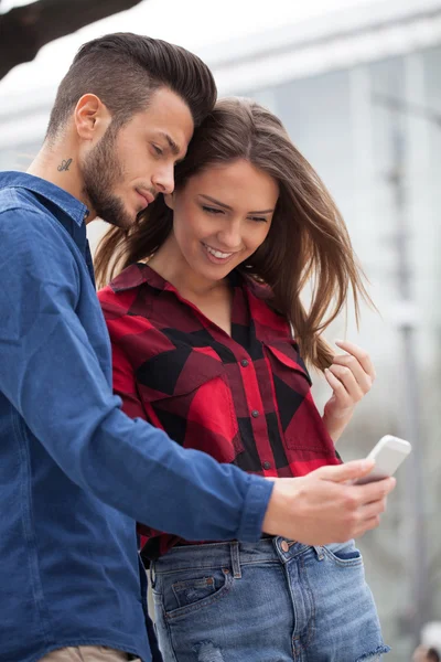Jeune couple utilisant un téléphone intelligent — Photo