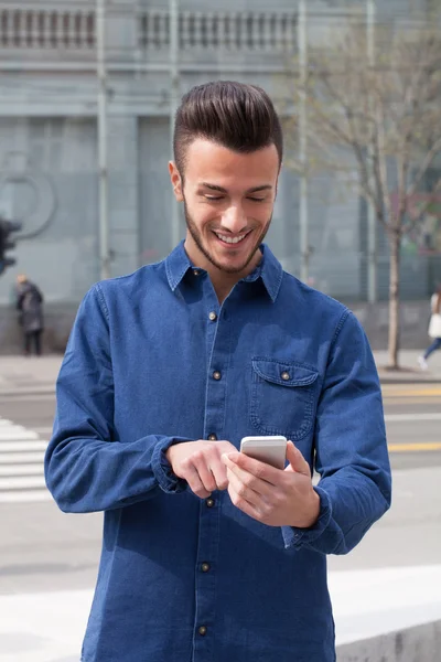 Jeune homme utilisant un téléphone intelligent — Photo