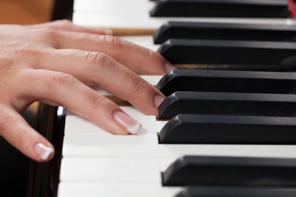 En kvinna som spelar piano — Stockfoto