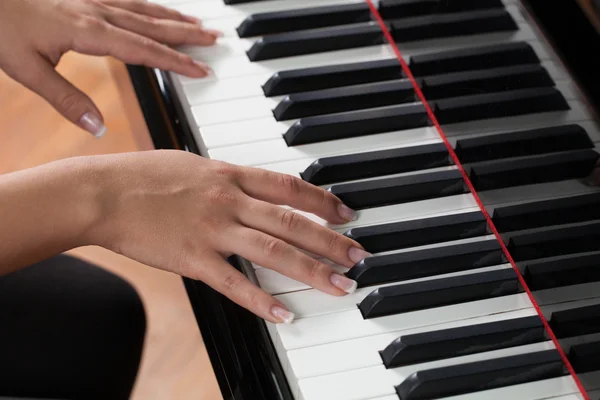 Een vrouw speelt piano — Stockfoto