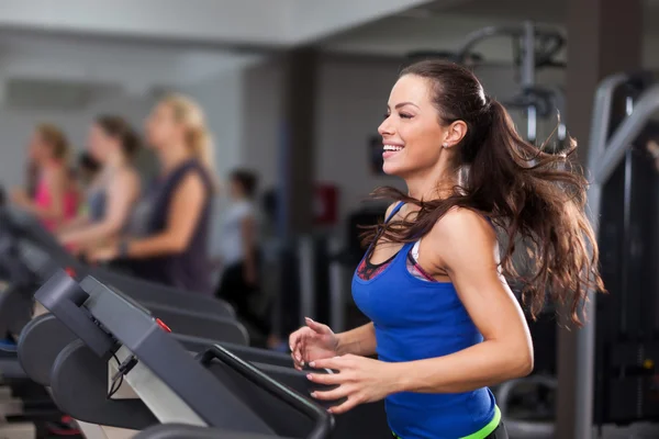 Hermosa morena en una cinta de correr — Foto de Stock