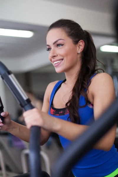 Mujer joven haciendo ejercicio en un stepper — Foto de Stock