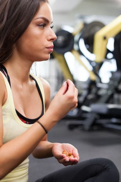 Mujer feliz teniendo un descanso de hacer ejercicio en el gimnasio — Foto de Stock