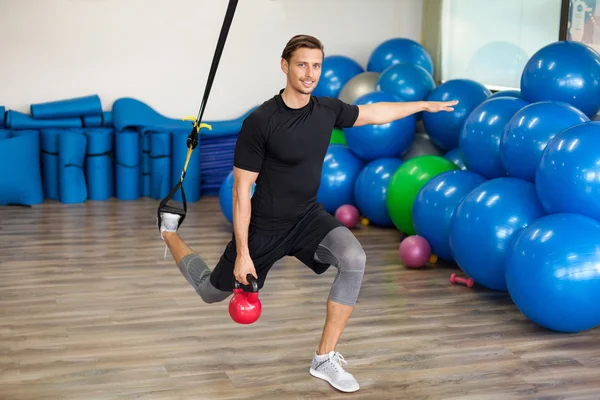 Hombre feliz haciendo ejercicios de estiramiento en un club de salud — Foto de Stock